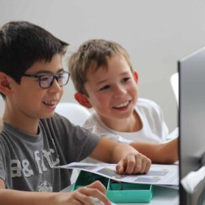 2 enfants 9-14 ans heureux en regardant l'ordi zoomé
