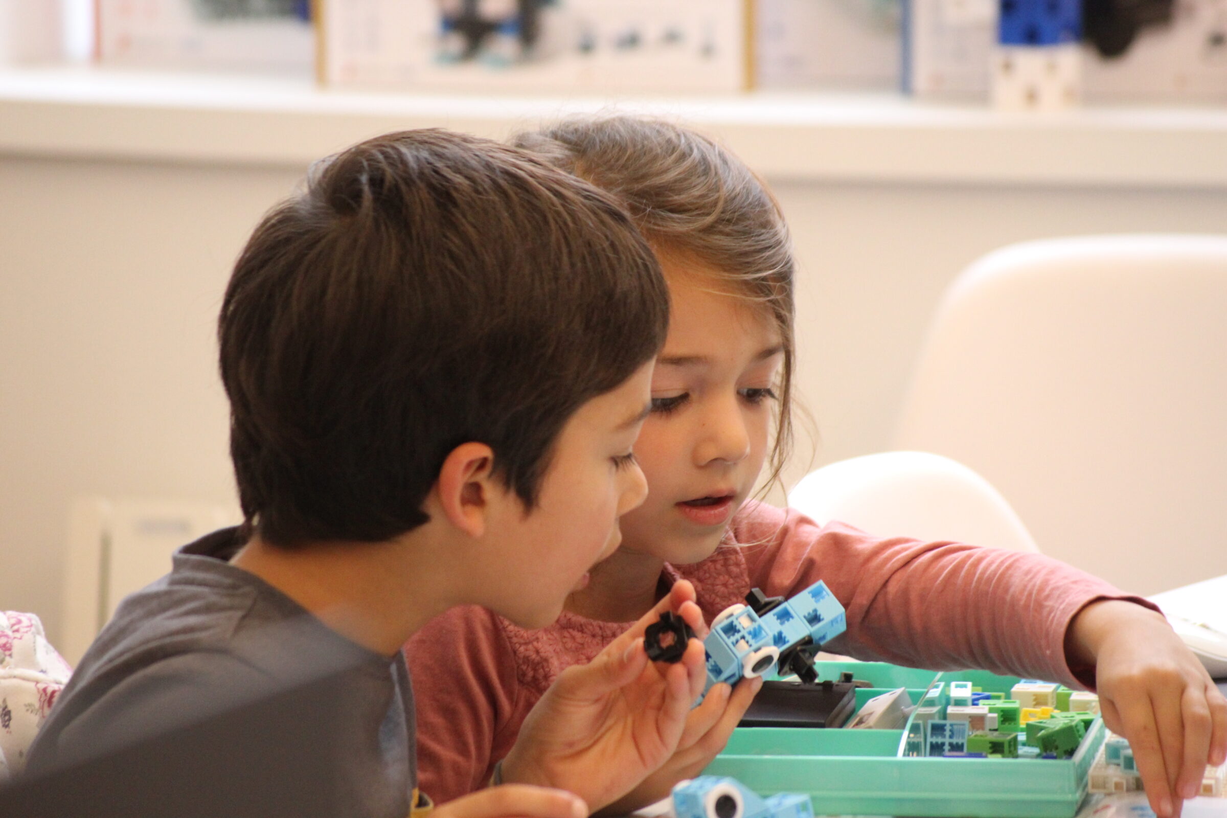 enfants regardant les pièces de robot de près lors d'un atelier dans le club de Pontchâteau