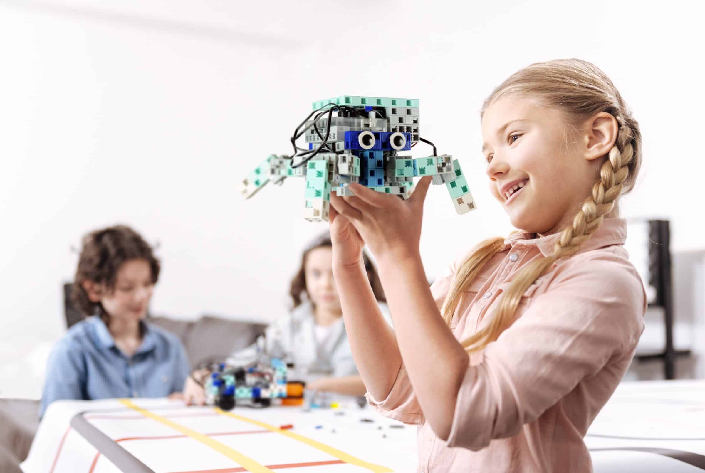 Jeune fille tenant un robot araignée qu'elle a réalisé