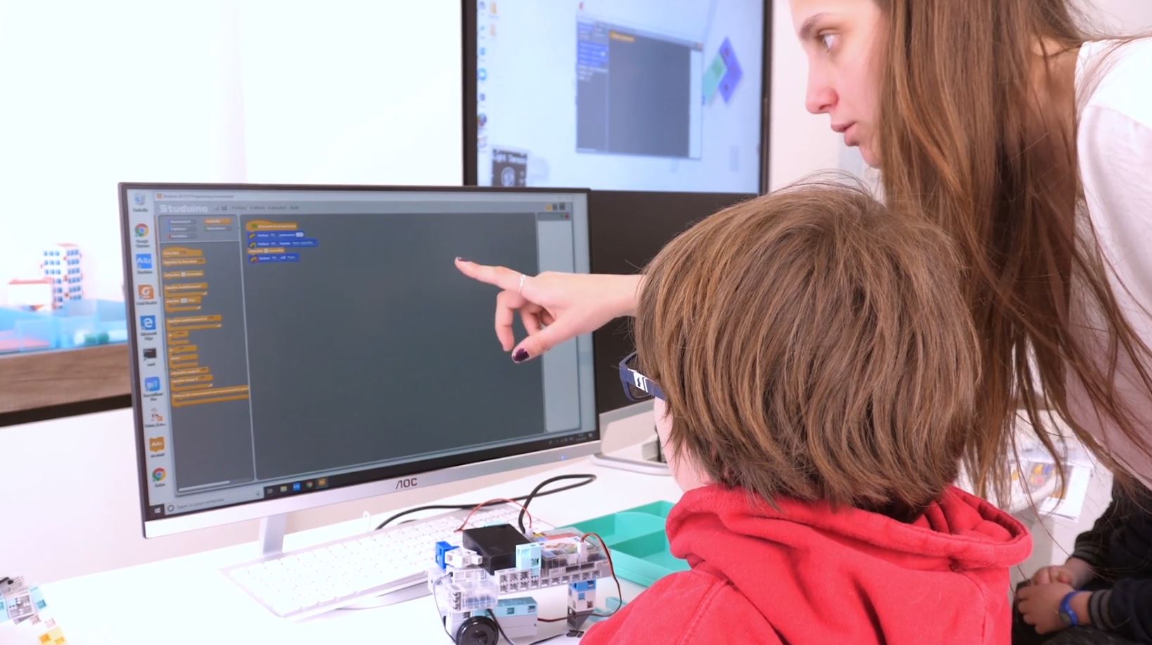 Prof montrant le code scratch blocs sur ordinateur à son élève à Algora Nantes