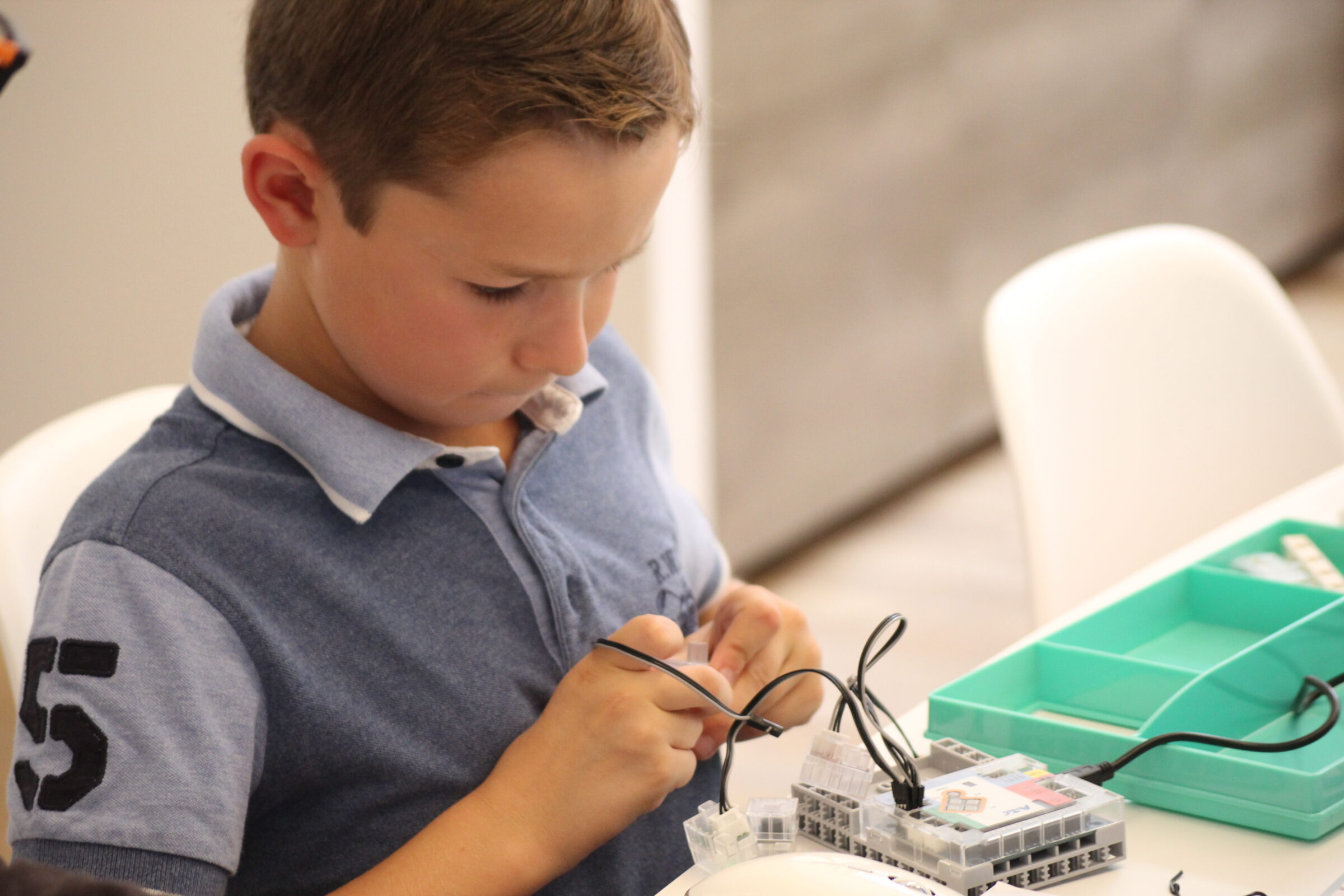 Garçon connectant un capteur sur une carte Arduino